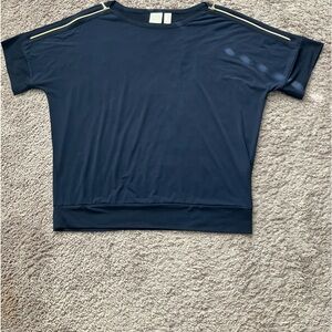 Chicos navy knot top with gold accent zippers on shoulder.